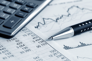 Spreadsheet, charts, calculator, and pen, illustrating financials calculation